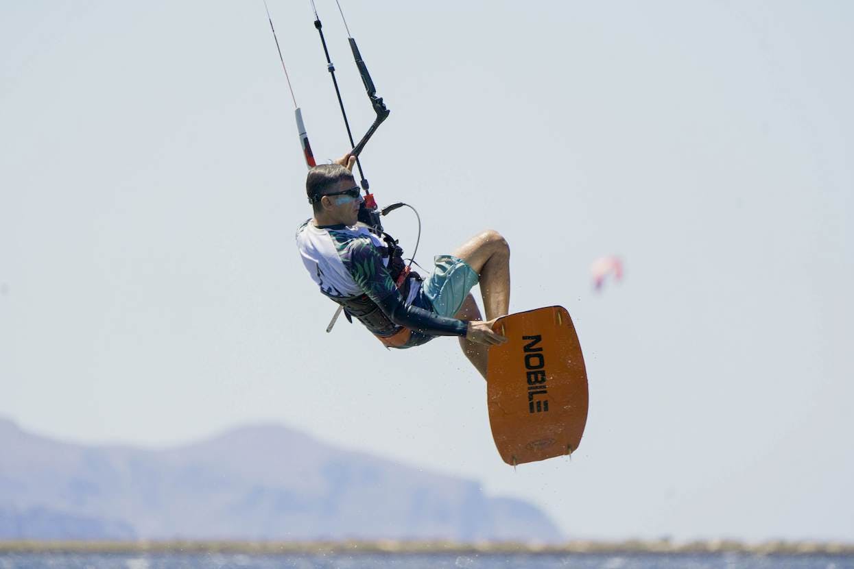 kitesurfer jumping with a nose grab